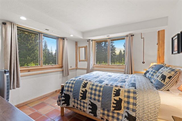 bedroom with multiple windows and tile patterned flooring