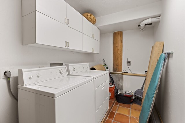 washroom featuring washer and clothes dryer, light tile patterned flooring, and cabinets