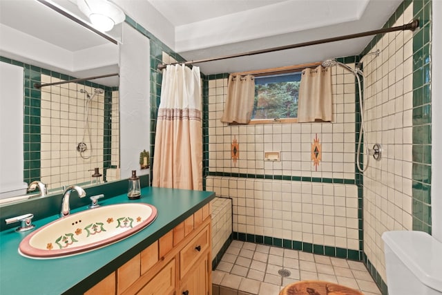 bathroom with tile patterned flooring, toilet, vanity, tile walls, and a shower with shower curtain