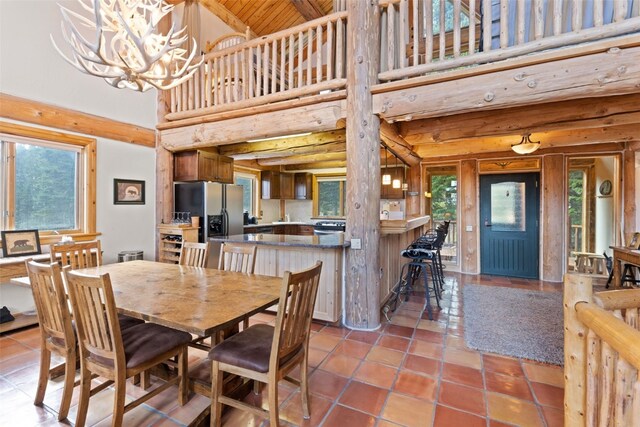 dining area featuring tile patterned flooring, a notable chandelier, wood ceiling, and high vaulted ceiling