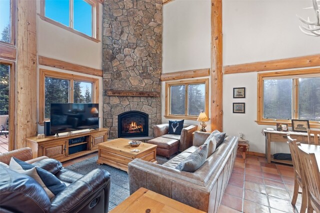 living room featuring a fireplace, a towering ceiling, and light tile patterned flooring