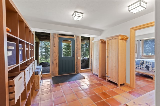 tiled entrance foyer with a textured ceiling and a wealth of natural light