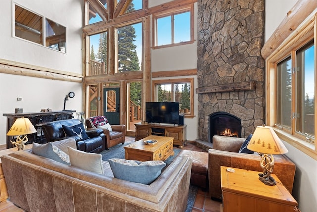 living room featuring a stone fireplace and a towering ceiling