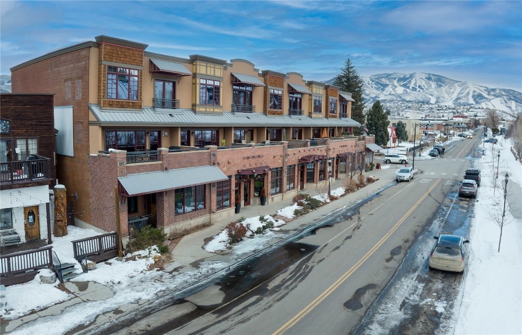 snow covered building featuring a mountain view