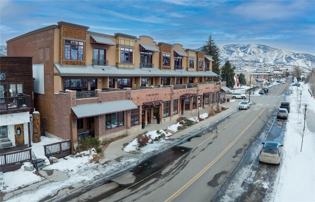 snow covered building featuring a mountain view