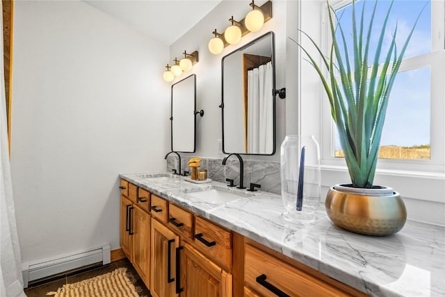 bathroom featuring baseboard heating and vanity