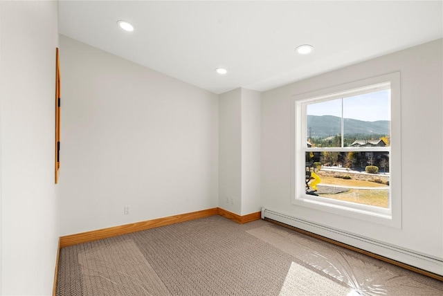 empty room featuring carpet, a mountain view, and baseboard heating