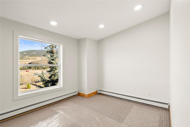 carpeted empty room featuring baseboard heating