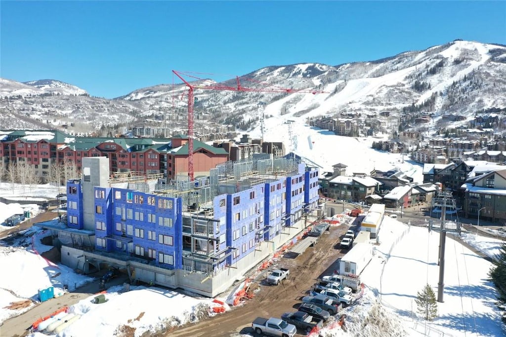 snowy aerial view featuring a mountain view