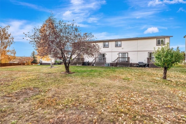 back of house featuring a wooden deck and a lawn