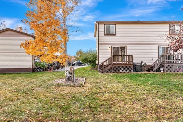 rear view of property featuring a lawn and a deck