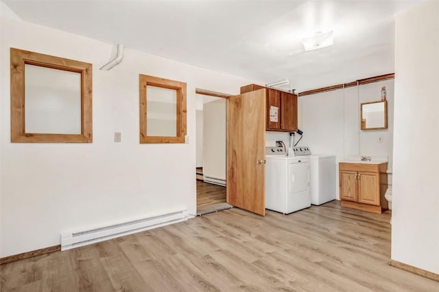 laundry room featuring cabinets, washing machine and clothes dryer, light hardwood / wood-style flooring, and a baseboard radiator