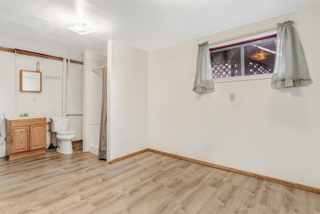 interior space featuring wood-type flooring, vanity, and toilet