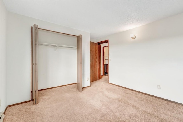 unfurnished bedroom with light colored carpet and a closet