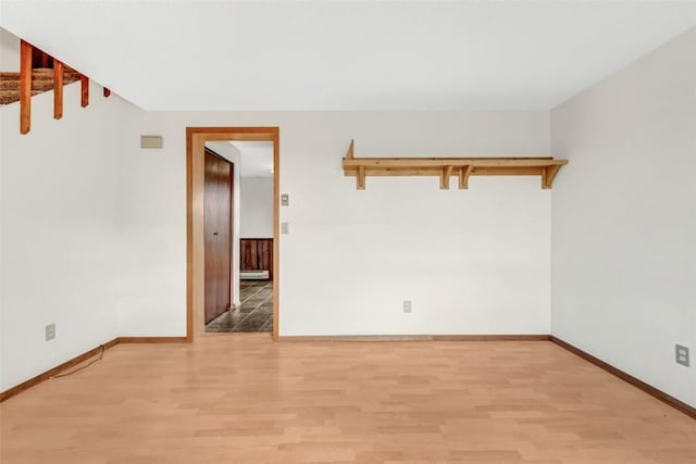 empty room featuring light wood-type flooring and a baseboard radiator