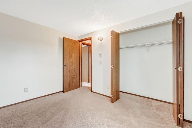 unfurnished bedroom featuring light colored carpet and a closet