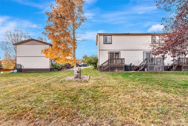 back of property featuring a lawn and a deck