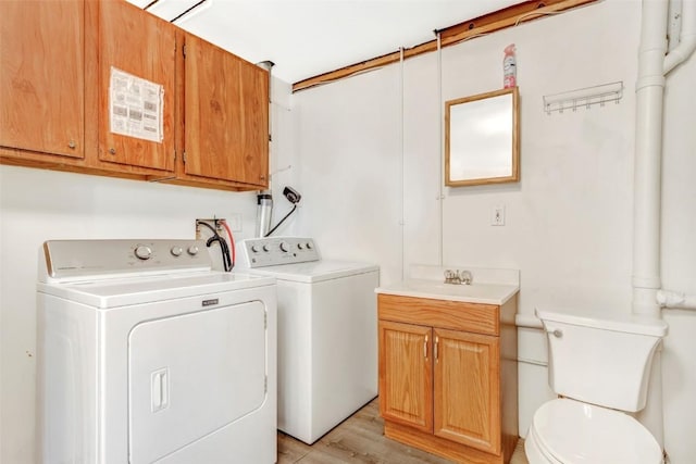 laundry room with separate washer and dryer, sink, and light wood-type flooring