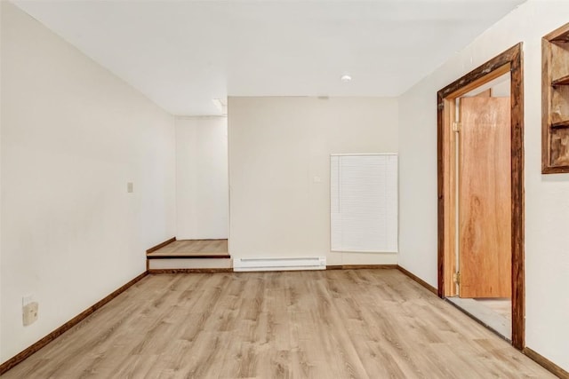 unfurnished room featuring light wood-type flooring and baseboard heating