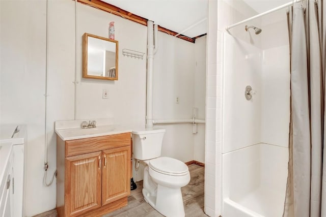 bathroom with hardwood / wood-style floors, vanity, toilet, and walk in shower