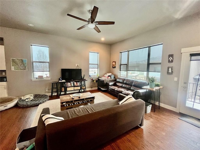 living room featuring baseboards, a ceiling fan, and wood finished floors