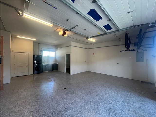 garage featuring electric panel, washer / dryer, and a garage door opener