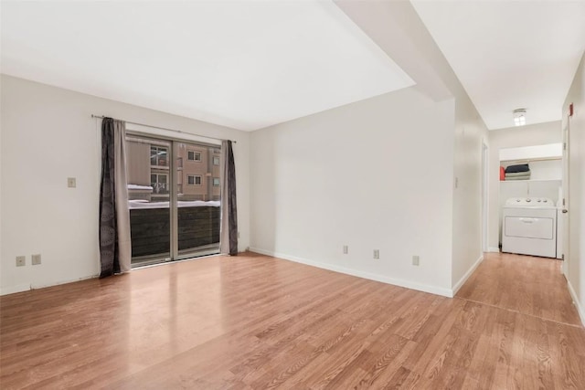 spare room with independent washer and dryer and light hardwood / wood-style flooring