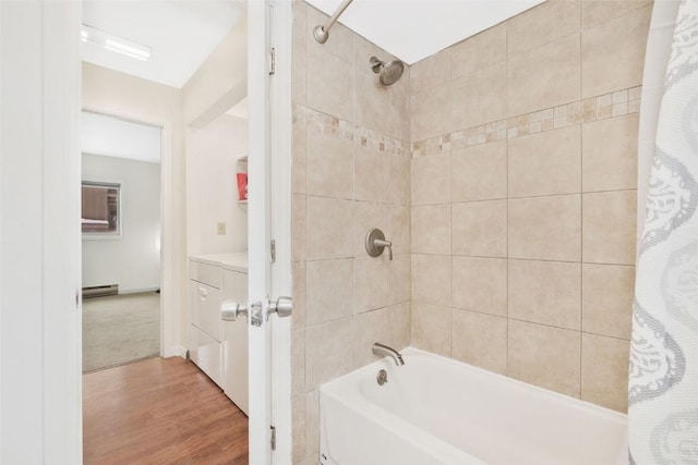 bathroom with hardwood / wood-style floors, shower / bath combination with curtain, and a baseboard radiator