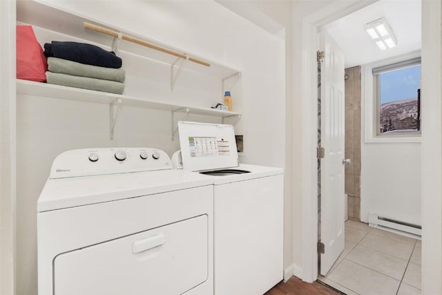 laundry area with light tile patterned floors, a baseboard radiator, and washing machine and clothes dryer