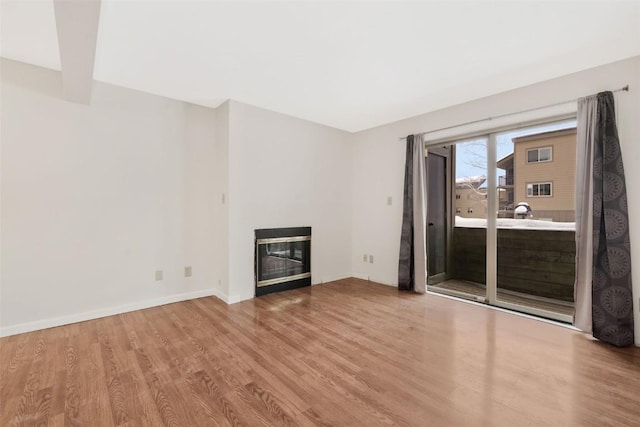 unfurnished living room with beamed ceiling and light hardwood / wood-style flooring