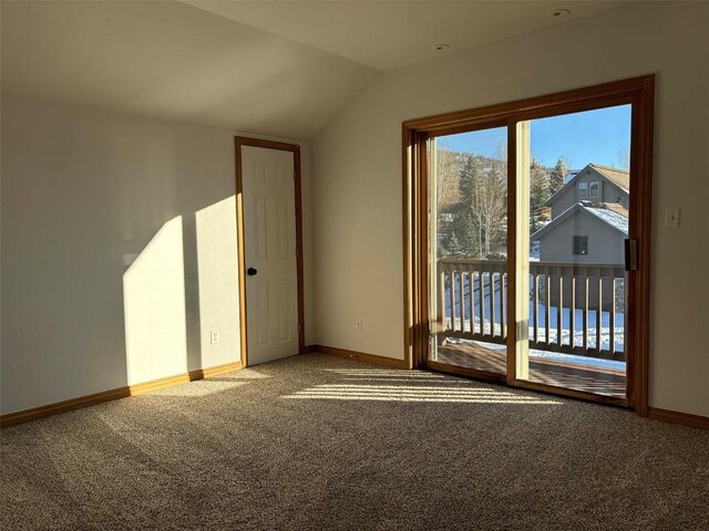 unfurnished room featuring carpet flooring and vaulted ceiling