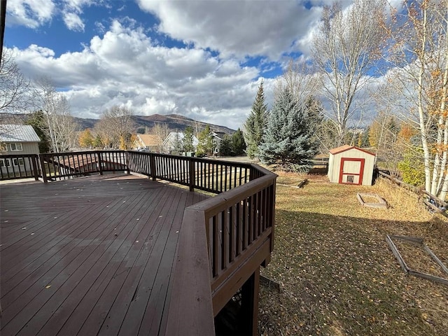 wooden deck featuring a mountain view and a storage shed