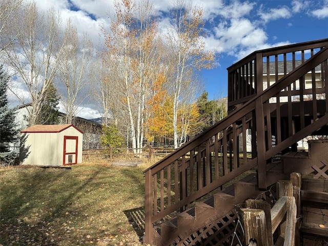 view of yard featuring a wooden deck and a storage unit