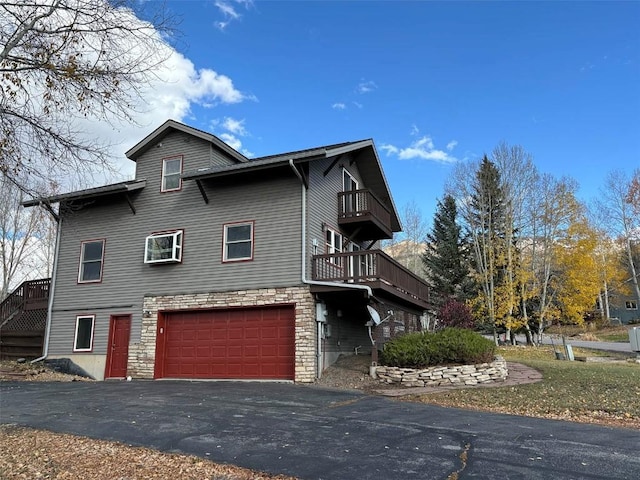 view of side of home with a balcony and a garage