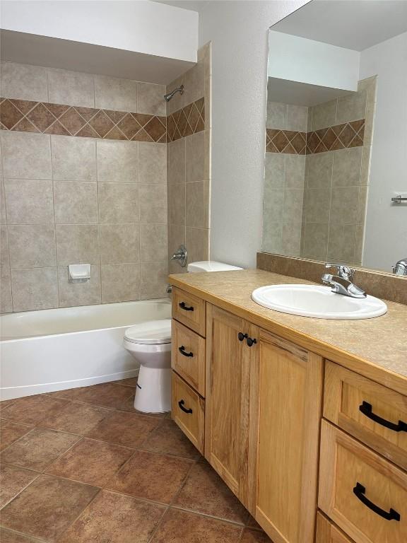 full bathroom featuring vanity, toilet, and tiled shower / bath