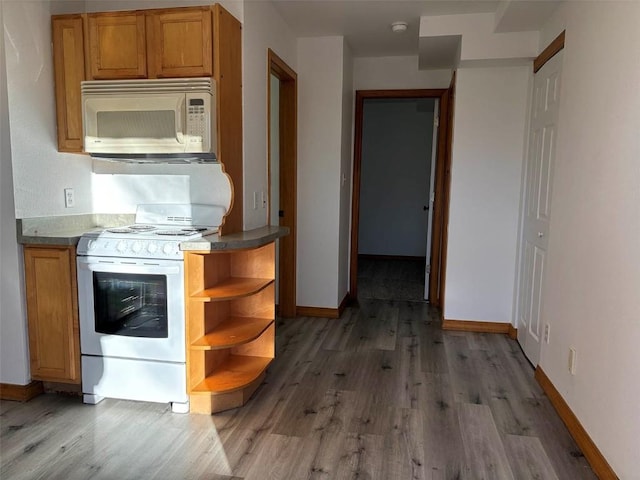 kitchen with dark hardwood / wood-style floors and white appliances