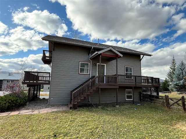 rear view of house featuring a lawn and a deck