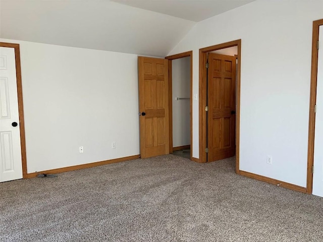 unfurnished bedroom featuring carpet and lofted ceiling