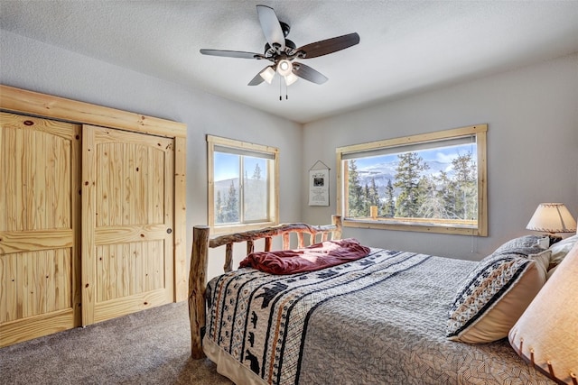 bedroom featuring a textured ceiling, ceiling fan, and carpet