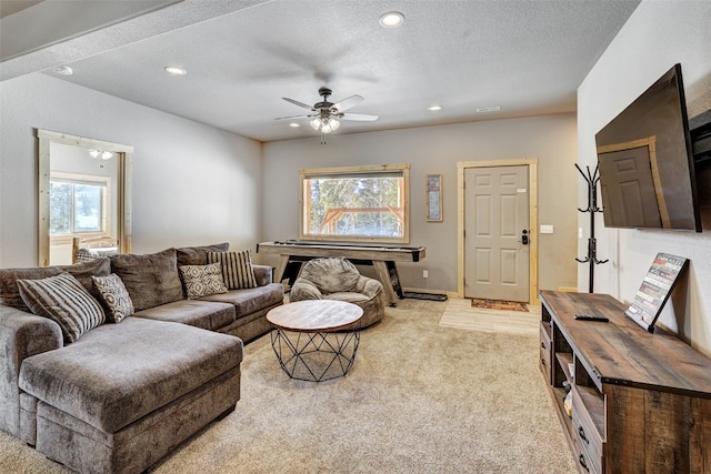 carpeted living room with ceiling fan and a textured ceiling