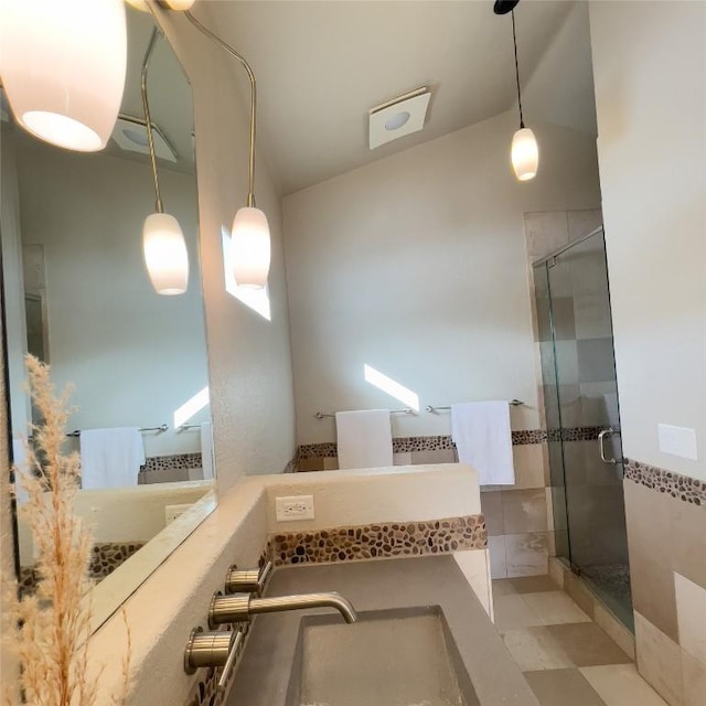 bathroom featuring a shower with door, lofted ceiling, and vanity