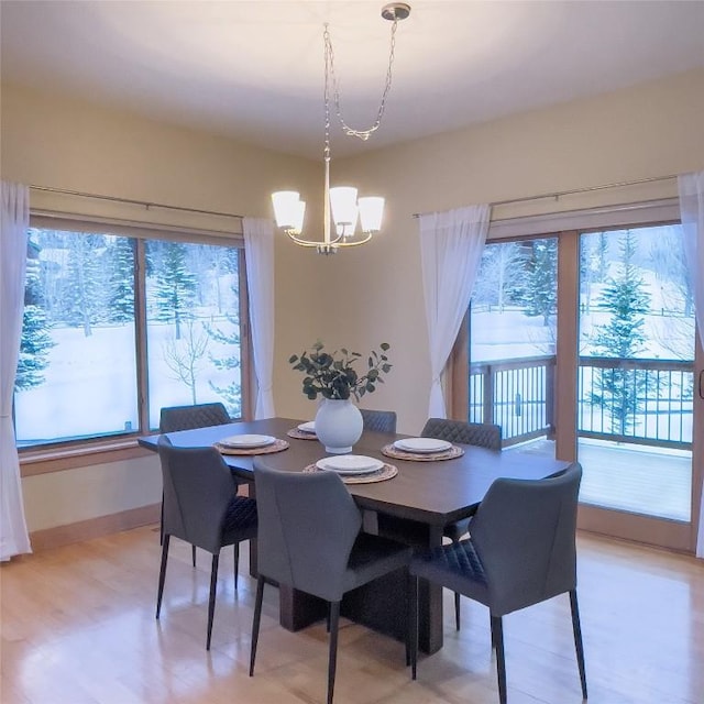 dining room with light wood-type flooring and a chandelier