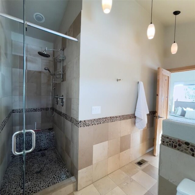 bathroom featuring tile walls and a shower with shower door