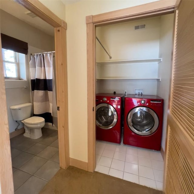 clothes washing area featuring washer and clothes dryer and light tile patterned floors