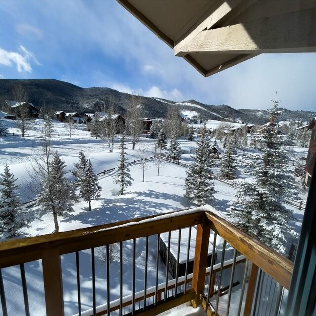 snow covered back of property with a mountain view