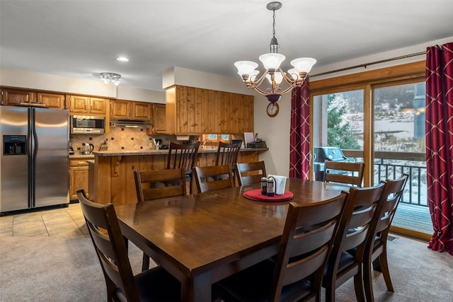 dining area with light colored carpet and an inviting chandelier