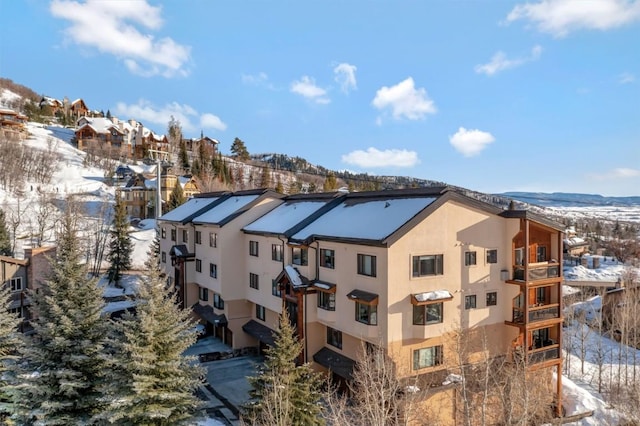 snow covered building featuring a residential view and a mountain view