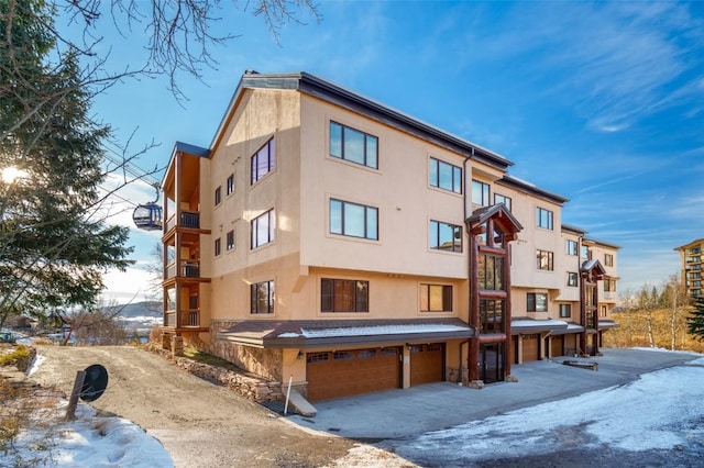 snow covered property featuring an attached garage