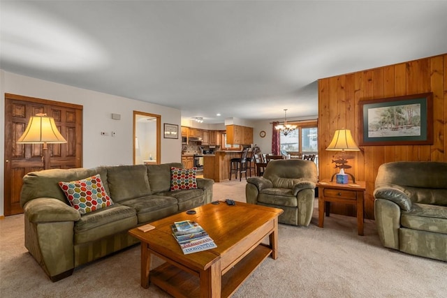 carpeted living room with wooden walls and a chandelier