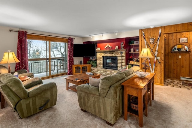 living room featuring light carpet, wooden walls, a baseboard radiator, and a fireplace